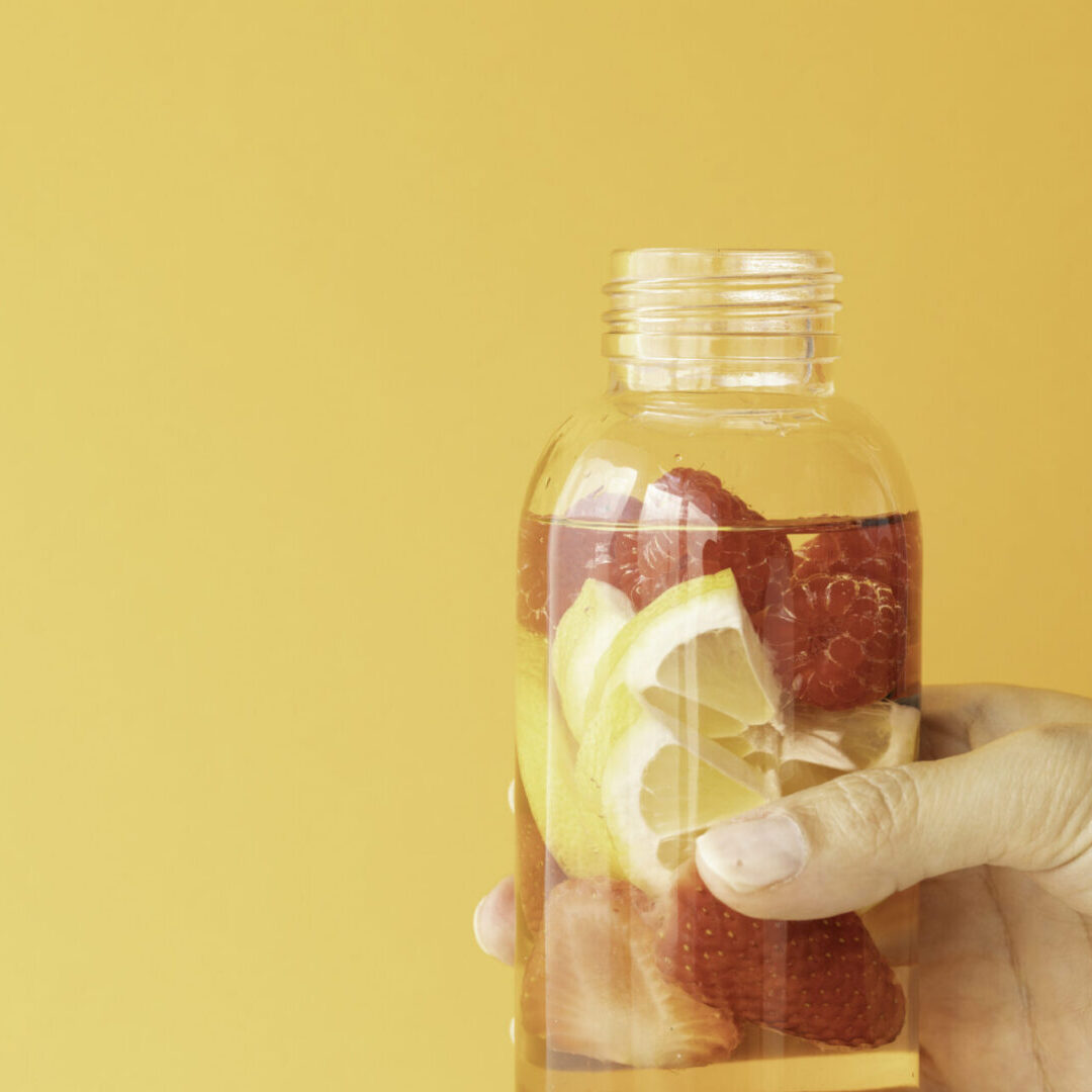 Hand holding fruit-infused water bottle